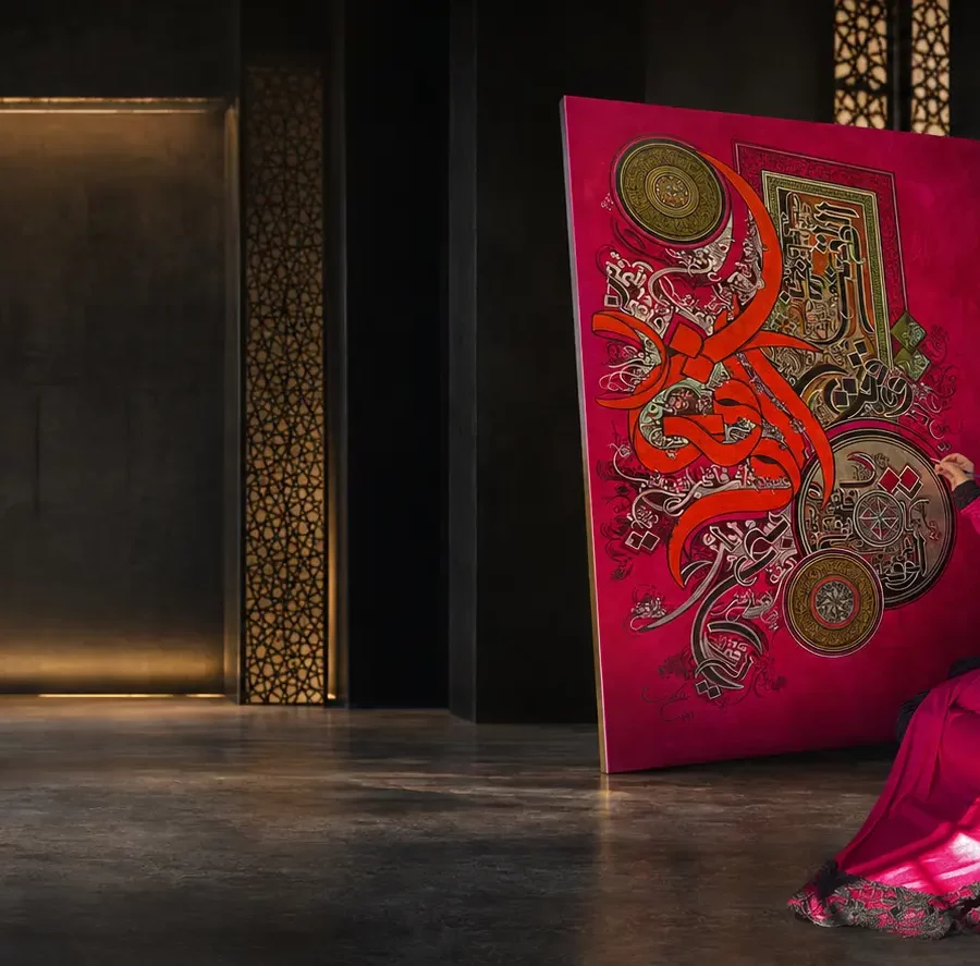Ayesha Kamal creating a monumental crimson calligraphic painting in a cinematic museum studio